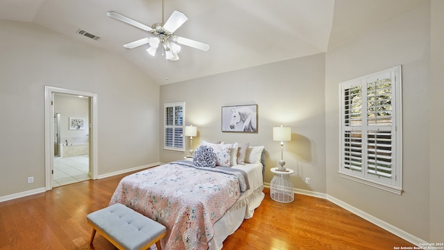 bedroom with ceiling fan, wood-type flooring, connected bathroom, and lofted ceiling