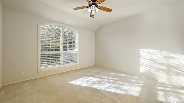 empty room featuring ceiling fan, light colored carpet, and vaulted ceiling