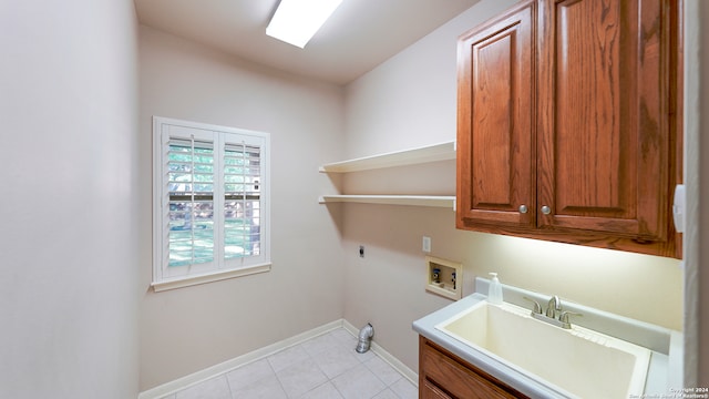 clothes washing area featuring hookup for an electric dryer, hookup for a washing machine, light tile patterned floors, cabinets, and sink