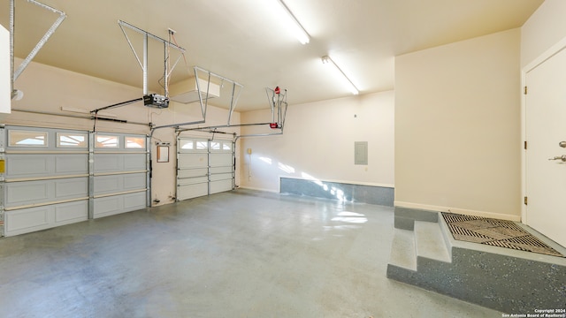 garage with a garage door opener and electric panel