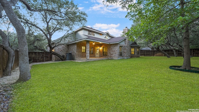 back of house with cooling unit, a lawn, and a patio