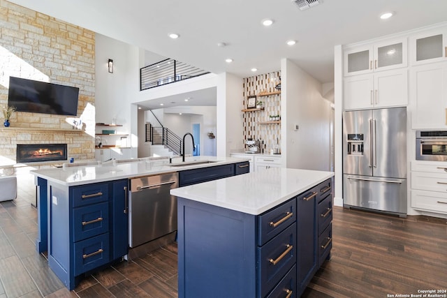 kitchen featuring dark hardwood / wood-style flooring, sink, a kitchen island, white cabinetry, and appliances with stainless steel finishes