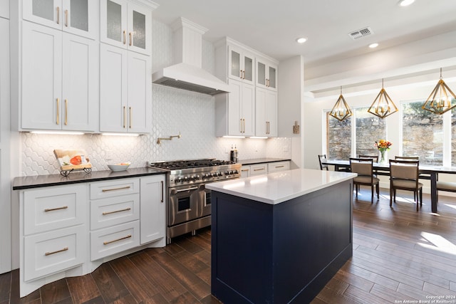 kitchen featuring white cabinetry, tasteful backsplash, dark hardwood / wood-style floors, range with two ovens, and premium range hood