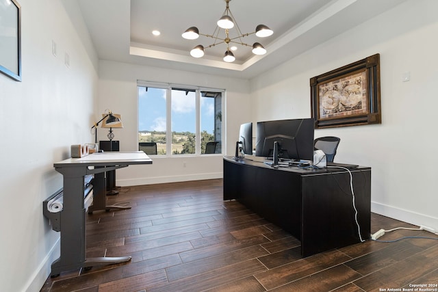 office area with dark hardwood / wood-style flooring, a raised ceiling, and an inviting chandelier