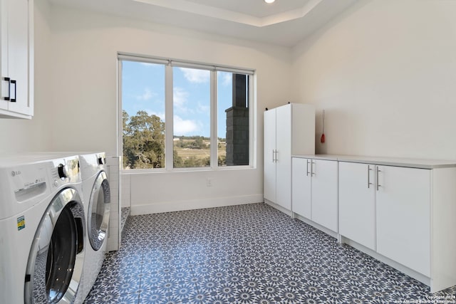 clothes washing area with cabinets and washing machine and clothes dryer