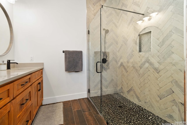 bathroom with hardwood / wood-style flooring, vanity, and an enclosed shower