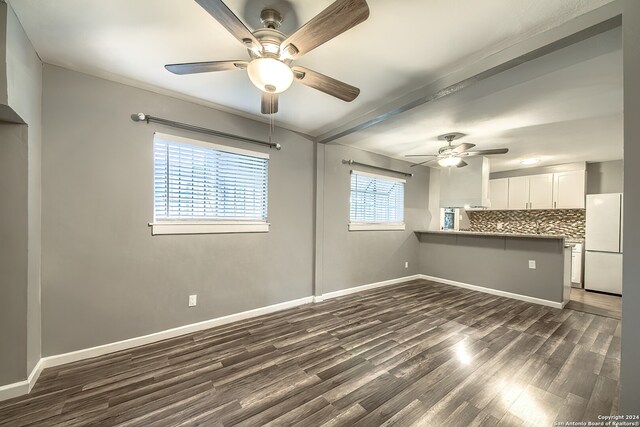 interior space with dark hardwood / wood-style flooring, beamed ceiling, and ceiling fan