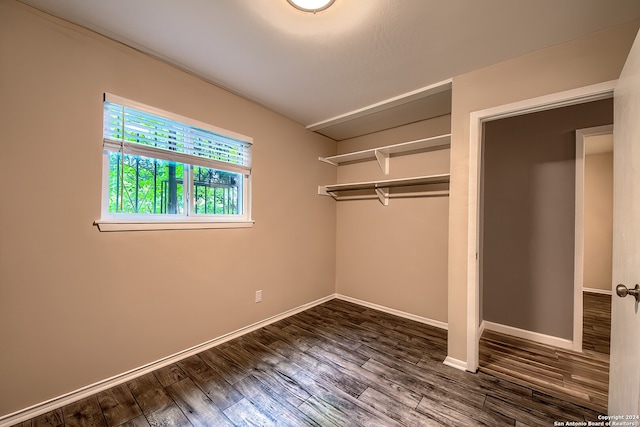 unfurnished bedroom featuring dark hardwood / wood-style flooring and a closet