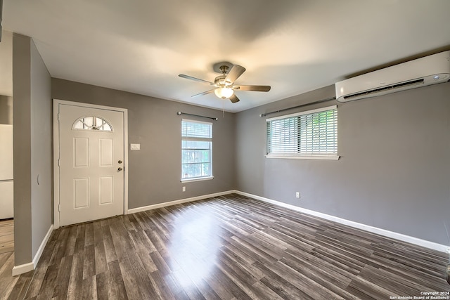 entrance foyer with dark wood-type flooring, a wall mounted AC, plenty of natural light, and ceiling fan