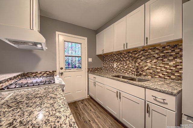 kitchen with white cabinetry, sink, and light stone counters