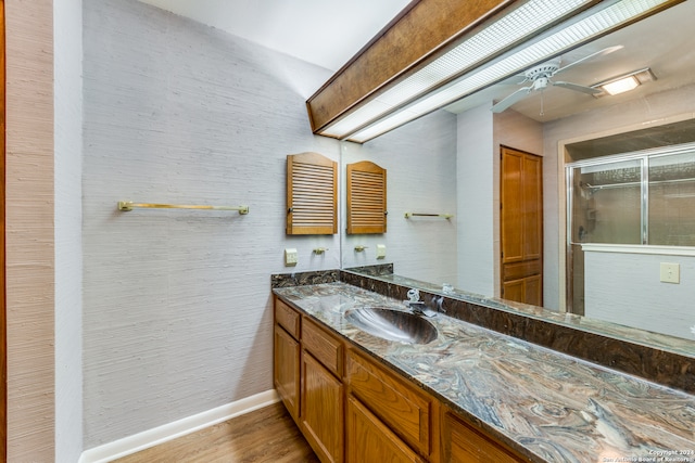 bathroom featuring hardwood / wood-style floors, walk in shower, ceiling fan, and vanity