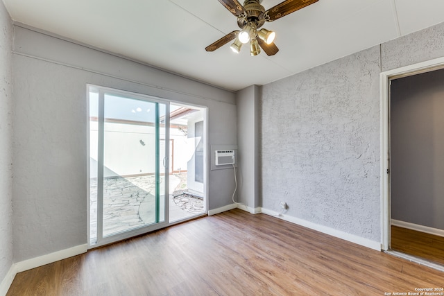 empty room with hardwood / wood-style floors, ceiling fan, and a wall mounted air conditioner