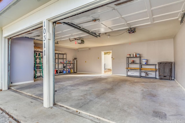10311 Grand Cir, San Antonio, TX 78239 - garage with a garage door opener, water heater, and baseboards