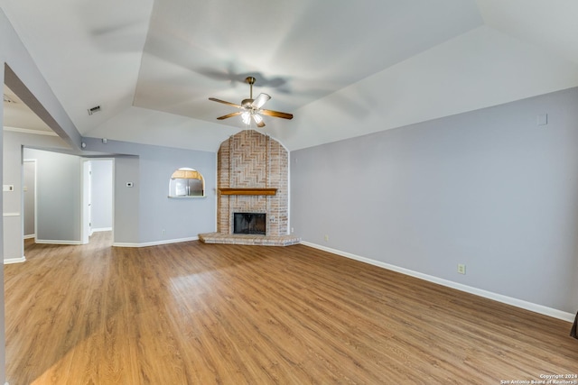 10311 Grand Cir, San Antonio, TX 78239 - unfurnished living room featuring a ceiling fan, lofted ceiling, baseboards, light wood-type flooring, and a brick fireplace