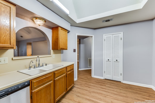 kitchen featuring lofted ceiling, sink, light hardwood / wood-style flooring, and dishwasher