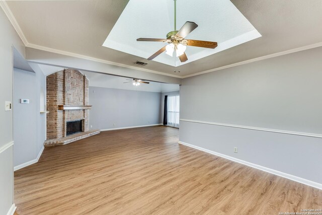 10311 Grand Cir, San Antonio, TX 78239 - unfurnished living room with wood finished floors, a ceiling fan, baseboards, ornamental molding, and a brick fireplace