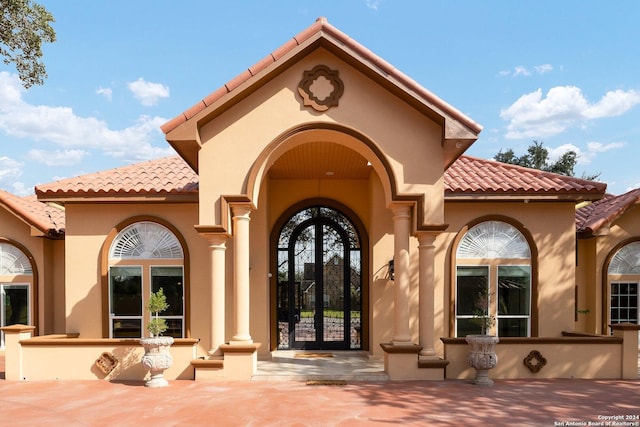 2301 Tanglewood, Weslaco, TX 78596 - view of exterior entry with a tile roof, french doors, and stucco siding