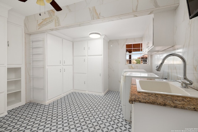 interior space featuring crown molding, cabinets, sink, washing machine and dryer, and ceiling fan