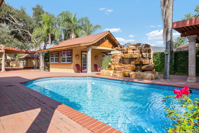 view of pool with a patio area and an outdoor structure