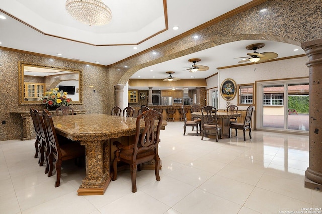 2301 Tanglewood, Weslaco, TX 78596 - dining space featuring arched walkways, a tray ceiling, crown molding, a ceiling fan, and decorative columns