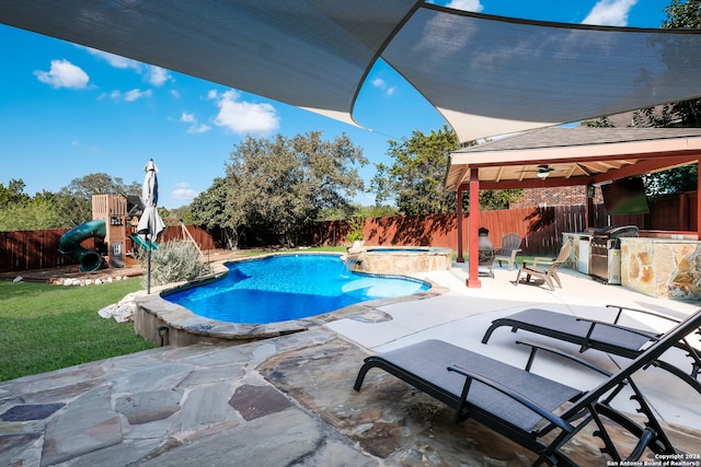 view of pool with grilling area, an in ground hot tub, an outdoor kitchen, ceiling fan, and a patio