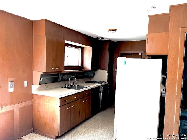 kitchen with black dishwasher, white refrigerator, sink, and stainless steel gas cooktop