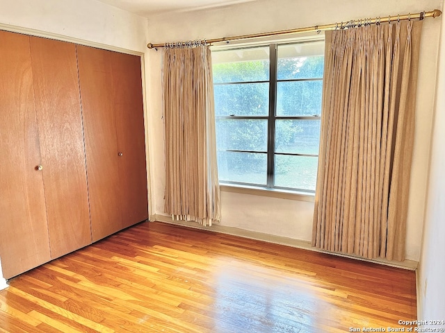 unfurnished bedroom with light hardwood / wood-style floors and a closet