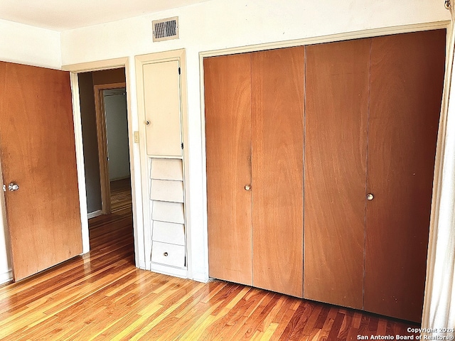 unfurnished bedroom with light hardwood / wood-style floors and a closet