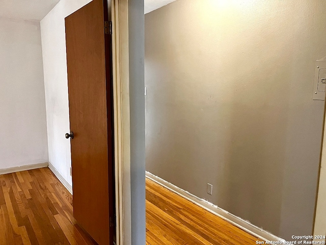 corridor with hardwood / wood-style floors