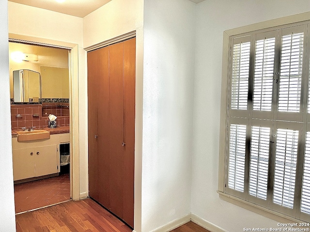 corridor with sink and light hardwood / wood-style floors