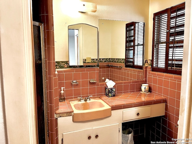 bathroom with vanity and tile walls