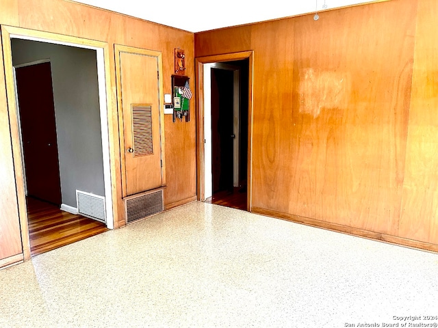 spare room featuring wooden walls