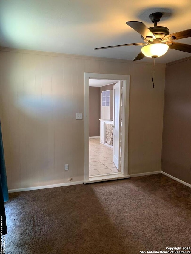 unfurnished room featuring ornamental molding, ceiling fan, and light colored carpet