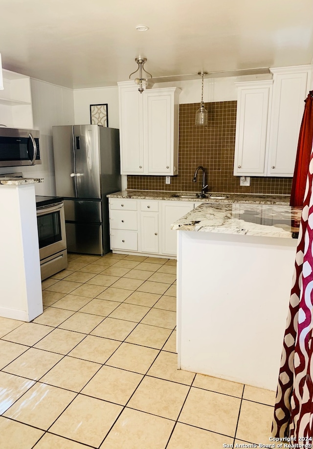 kitchen with white cabinets, decorative backsplash, stainless steel appliances, and sink