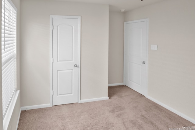 unfurnished bedroom featuring light colored carpet