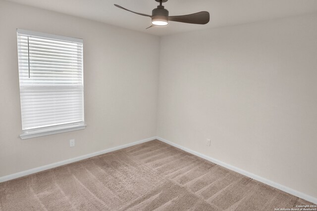 carpeted empty room featuring ceiling fan