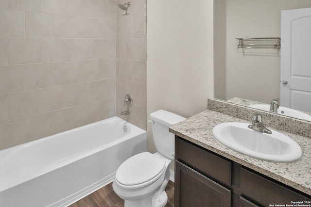 full bathroom featuring hardwood / wood-style floors, vanity, toilet, and tiled shower / bath