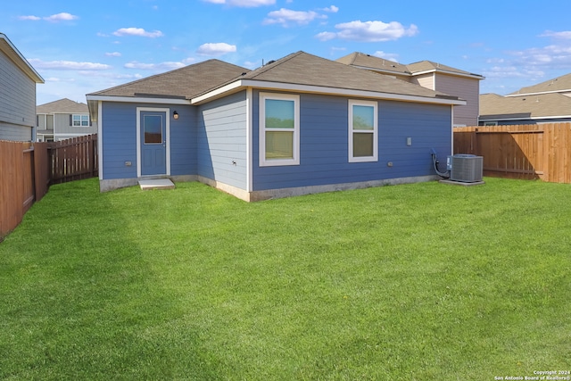 rear view of house featuring a yard and cooling unit