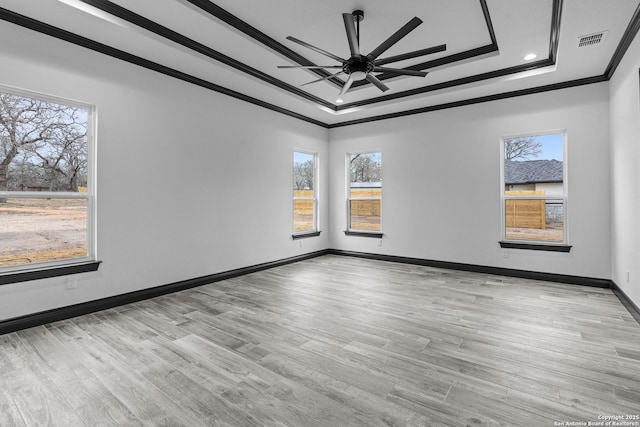 unfurnished room featuring a tray ceiling, ornamental molding, light hardwood / wood-style floors, and ceiling fan