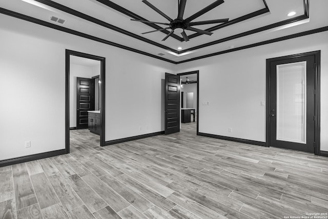 empty room featuring ceiling fan, a raised ceiling, and light hardwood / wood-style flooring