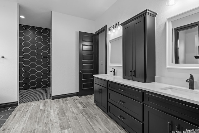 bathroom featuring vanity, hardwood / wood-style floors, and a tile shower