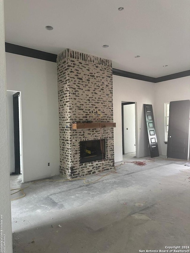 unfurnished living room featuring crown molding and a fireplace