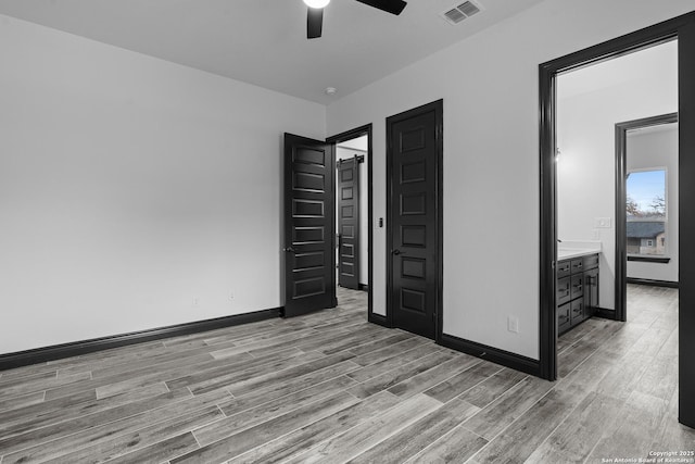 unfurnished bedroom featuring ceiling fan, connected bathroom, and light hardwood / wood-style floors