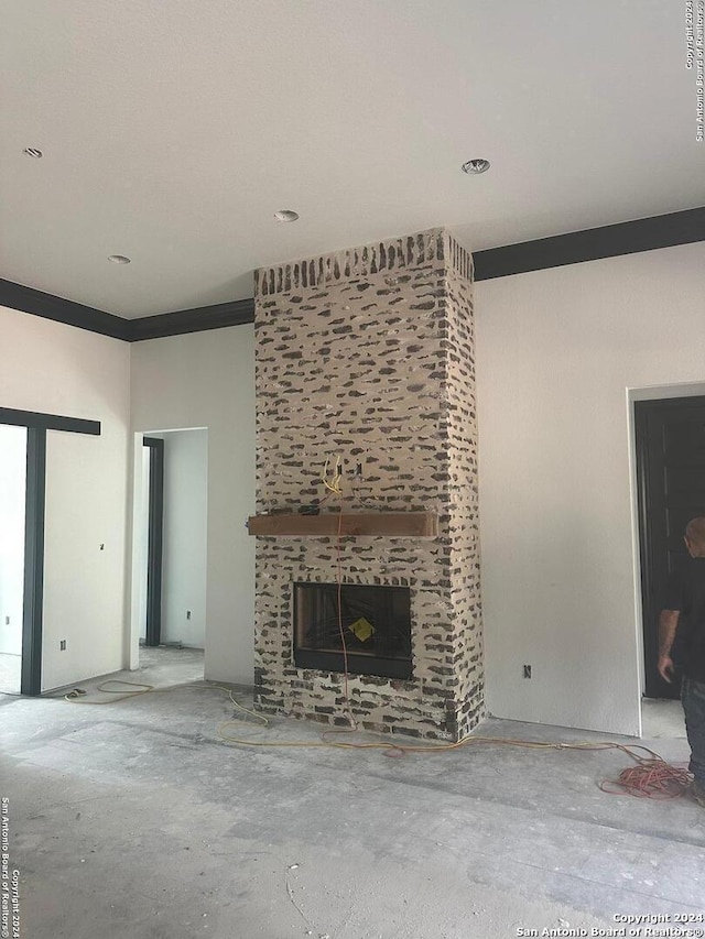 unfurnished living room featuring ornamental molding and a fireplace