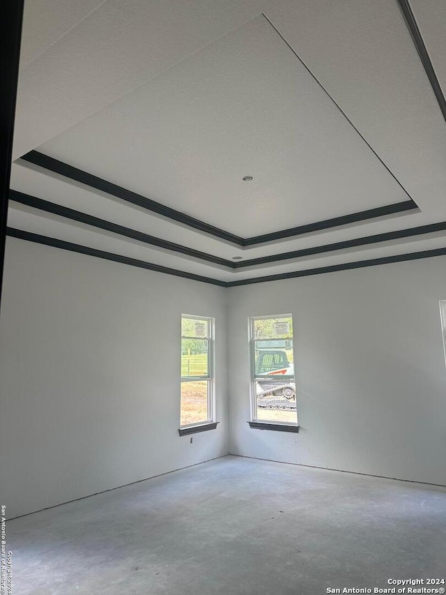 unfurnished room featuring concrete flooring and a raised ceiling