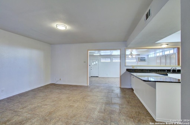 6810 Crown Rdg, San Antonio, TX 78239 - kitchen with dark countertops, baseboards, a peninsula, and a ceiling fan