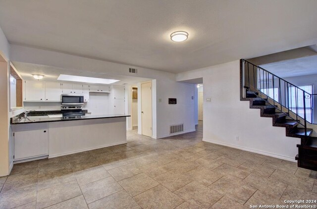6810 Crown Rdg, San Antonio, TX 78239 - kitchen with appliances with stainless steel finishes, a peninsula, open floor plan, white cabinets, and baseboards
