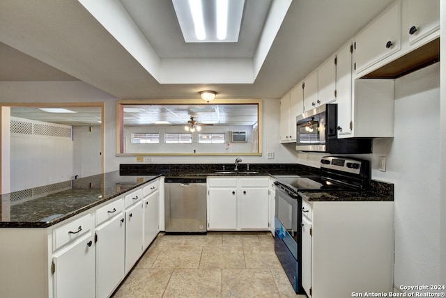 kitchen featuring white cabinetry, sink, dark stone countertops, a raised ceiling, and stainless steel appliances