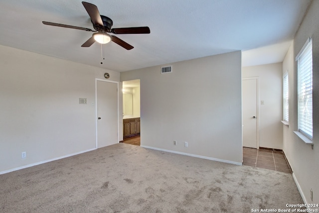 empty room with light colored carpet and ceiling fan