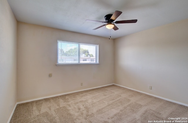 spare room featuring light carpet and ceiling fan